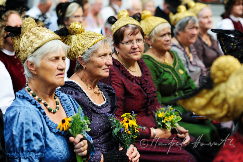 Besucher der Messe in traditioneller Tracht