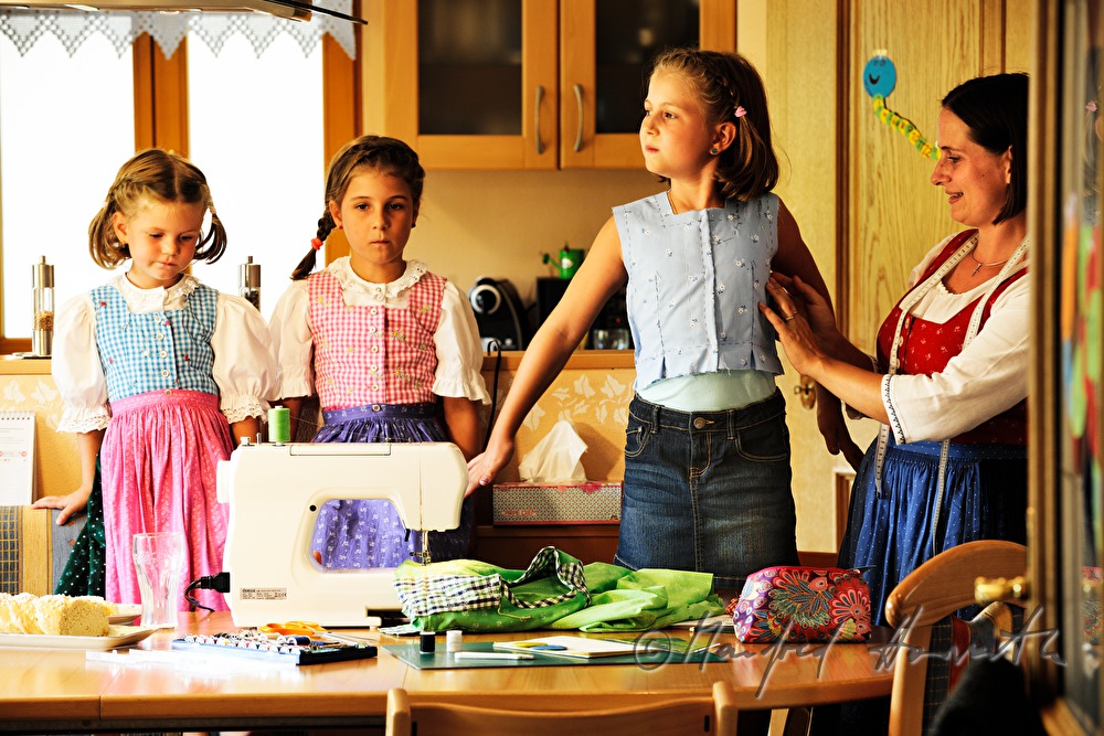 Mutter beim Schneidern eines Kinder-Dirndls