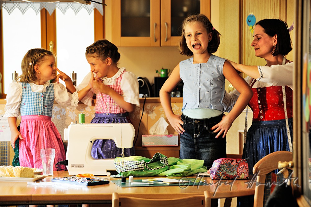 Mutter beim Schneidern eines Kinder-Dirndls