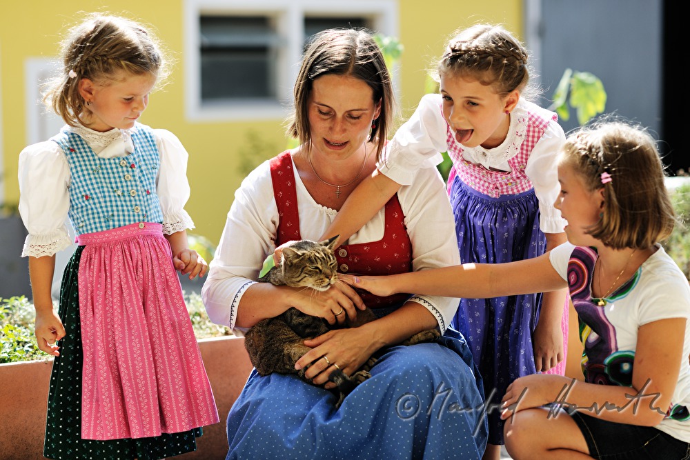 Mutter mit ihren drei Töchtern und Katze am Bauernhof