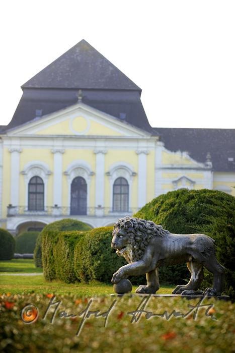 Skulptur eines Löwen und Gartenfront