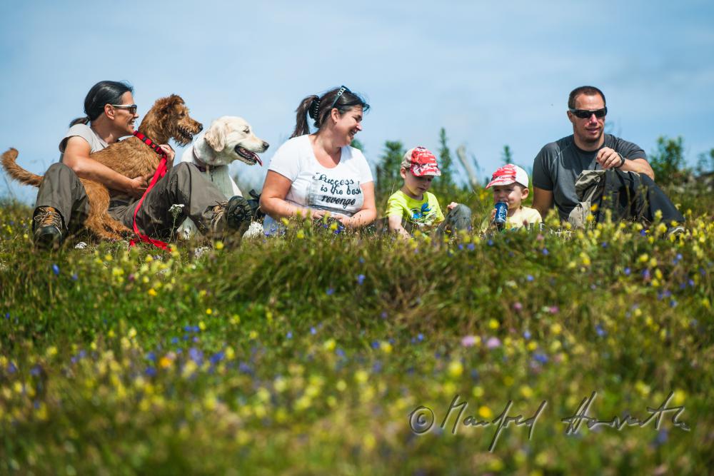 Wanderer mit Hunden rasten am Wegrand