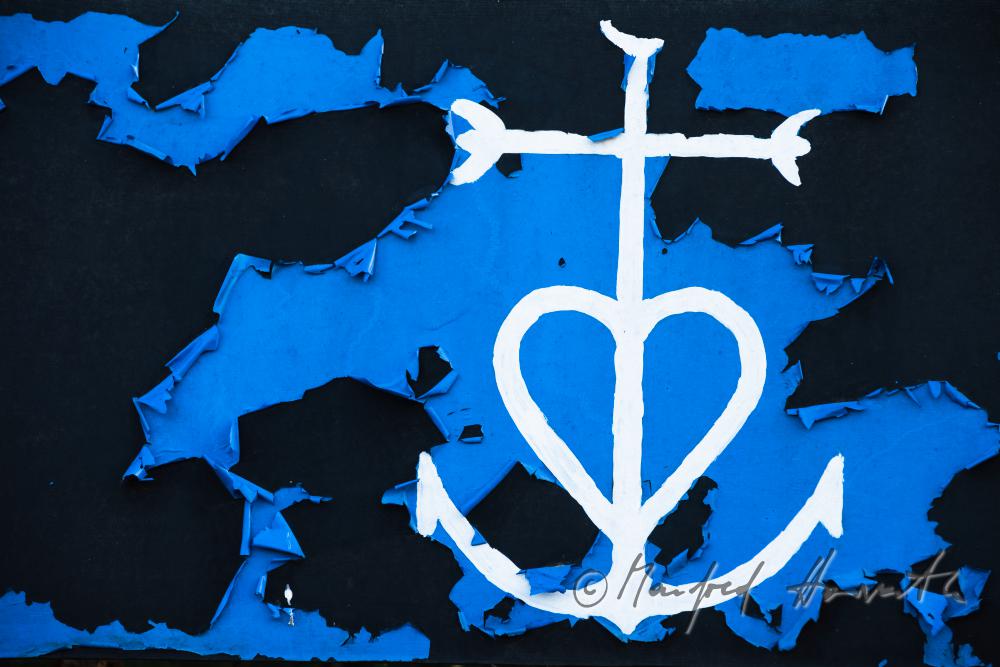 Camargue-Kreuz auf einer abblätternden Plakatwand