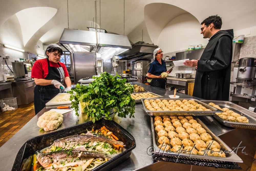 Küchenchefin und Mönche kochen in der Klosterküche