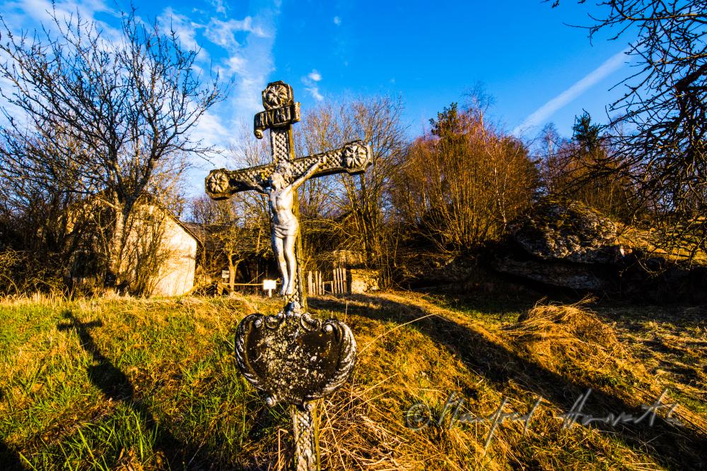 Grabkreuz bei einem Bauernhof im freien Feld