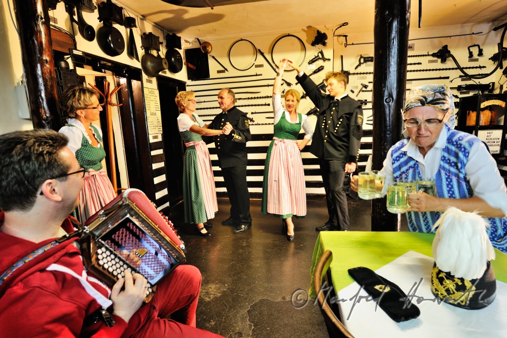 Frauen im Dirndl und Bergmänner tanzen im Bergmann-Museum
